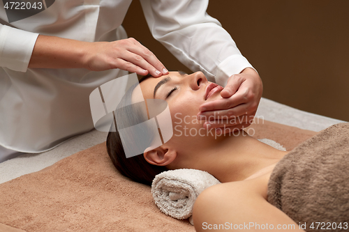 Image of woman having face and head massage at spa