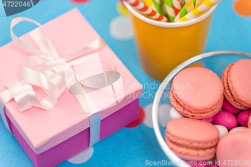 Image of birthday gift, macarons and paper straws for party