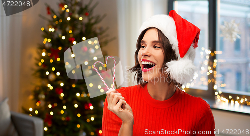 Image of happy young woman in santa hat on christmas