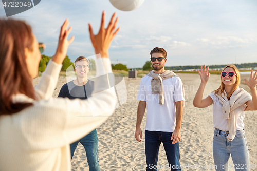 Image of friends playing volleyball on beach in summer