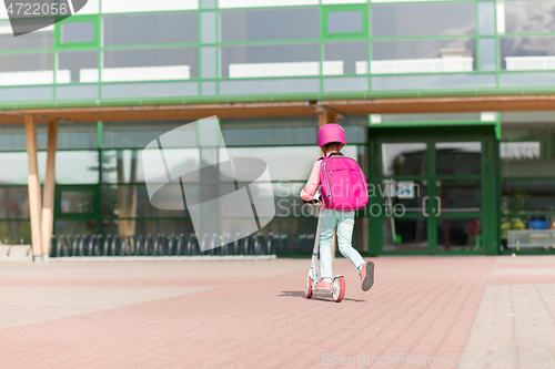 Image of school girl with backpack riding scooter