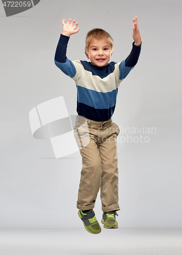 Image of happy little boy jumping in air