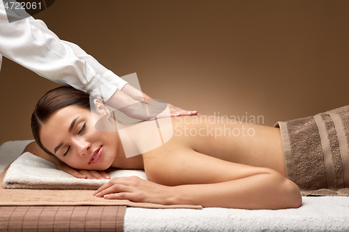 Image of woman lying and having back massage at spa