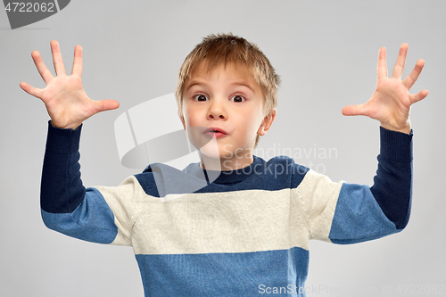 Image of portrait of little boy in striped pullover playing