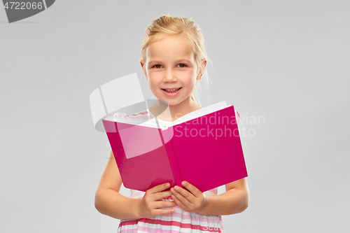 Image of smiling little girl reading book