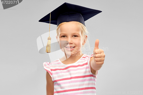 Image of little girl in mortarboard showing thumbs up