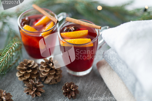 Image of mulled wine with orange and spices, cones and fir