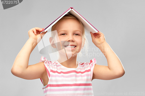 Image of little girl with roof of book on top of her head