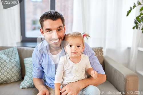 Image of father with little baby daughter at home