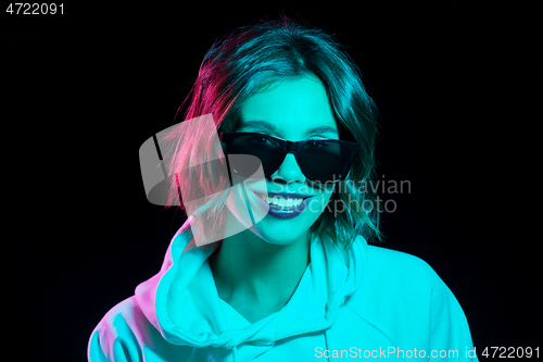 Image of woman wearing hoodie in neon lights over black