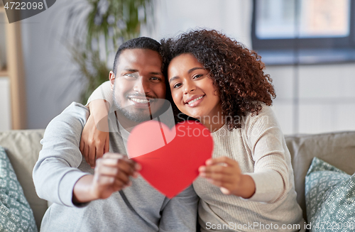 Image of happy african american couple with heart at home