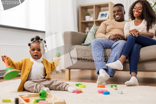 Image of african family with baby daughter playing at home