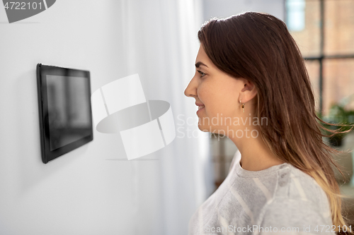 Image of woman looking at tablet computer at smart home