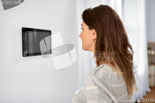 Image of woman looking at tablet computer at smart home