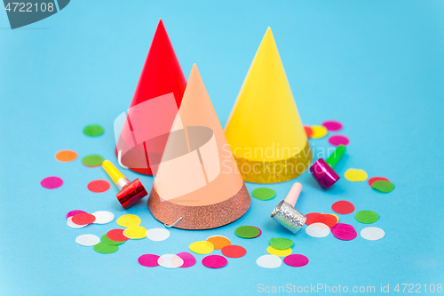 Image of birthday party caps, horns and colorful confetti