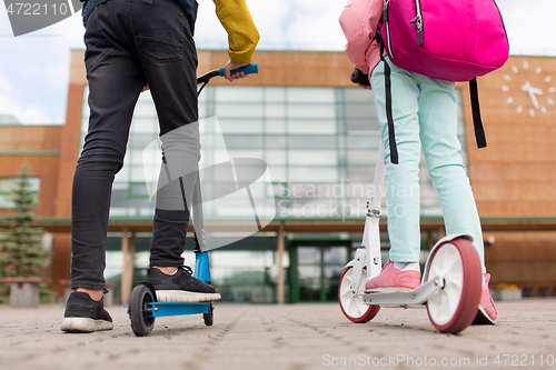 Image of school children with backpacks and scooters