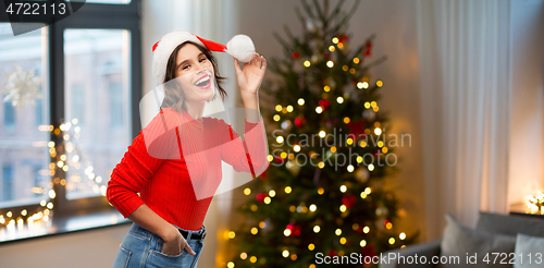 Image of happy young woman in santa hat on christmas