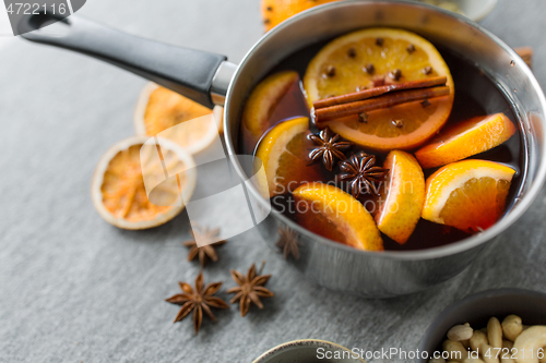 Image of pot with hot mulled wine, orange slices and spices