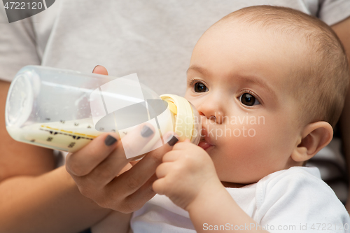 Image of close up of mother feeding baby with milk formula