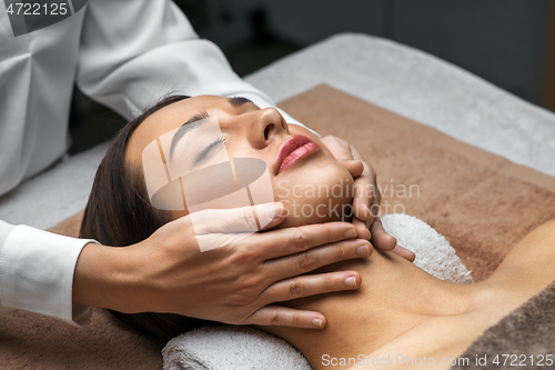 Image of woman having face and head massage at spa