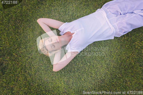 Image of top view of young woman relaxing on the grass