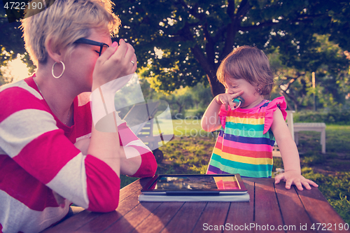 Image of mom and her little daughter using tablet computer