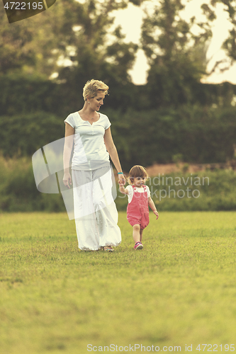 Image of mother and little daughter playing at backyard