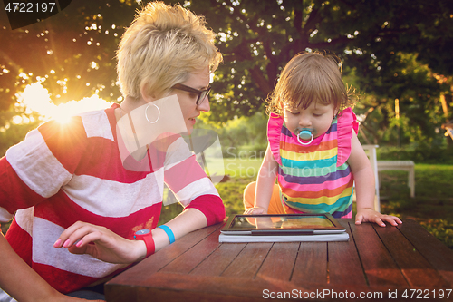 Image of mom and her little daughter using tablet computer