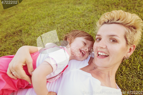 Image of mother and little daughter playing at backyard