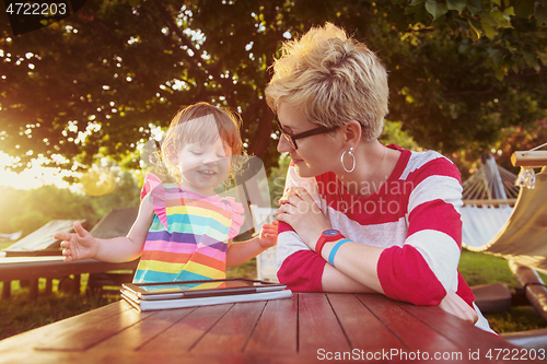 Image of mom and her little daughter using tablet computer