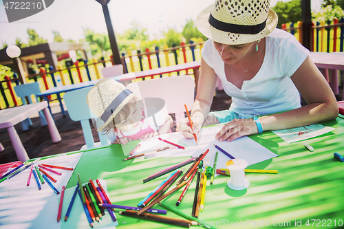 Image of mom and little daughter drawing a colorful pictures