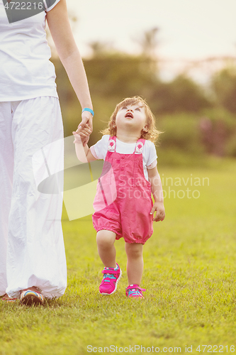 Image of mother and little daughter playing at backyard