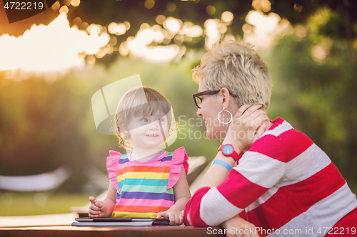 Image of mom and her little daughter using tablet computer