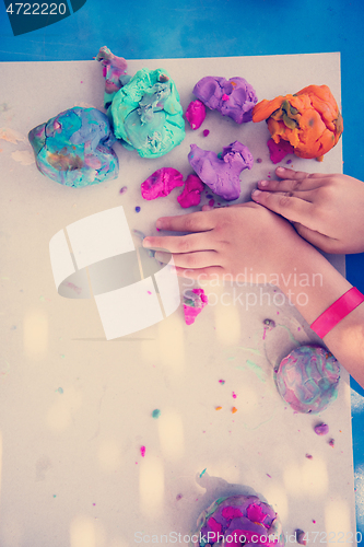 Image of kid hands Playing with Colorful Clay