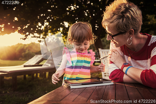 Image of mom and her little daughter using tablet computer