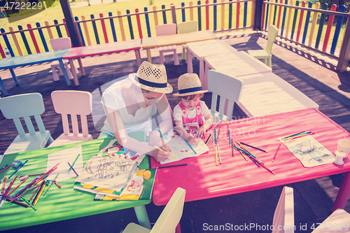 Image of mom and little daughter drawing a colorful pictures