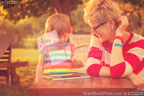 Image of mom and her little daughter using tablet computer