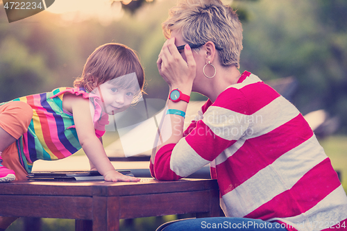 Image of mom and her little daughter using tablet computer