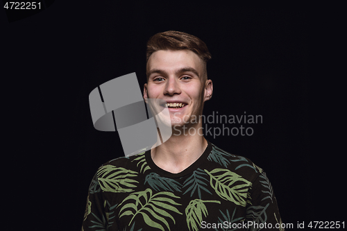 Image of Close up portrait of young man isolated on black studio background