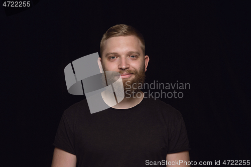 Image of Close up portrait of young man isolated on black studio background