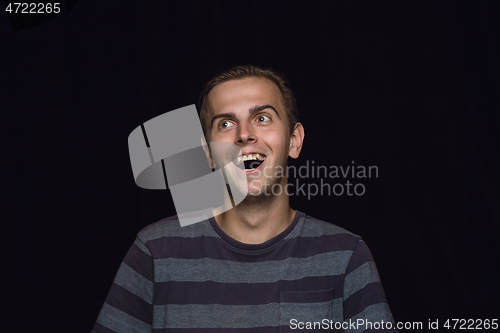 Image of Close up portrait of young man isolated on black studio background