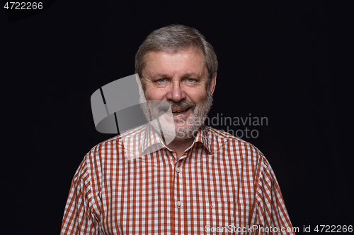 Image of Close up portrait of senior man isolated on black studio background