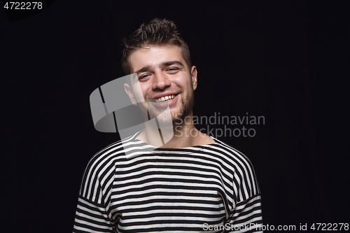 Image of Close up portrait of young man isolated on black studio background