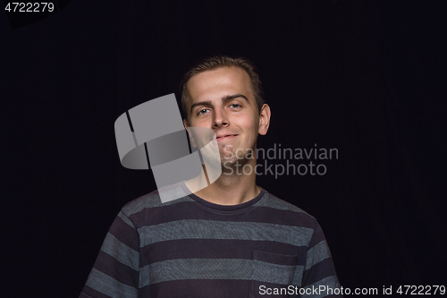 Image of Close up portrait of young man isolated on black studio background