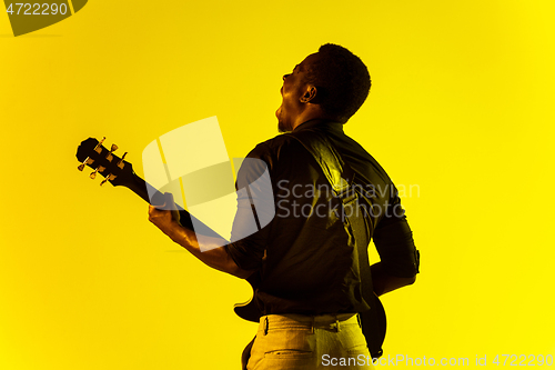 Image of Young african-american jazz musician playing the guitar