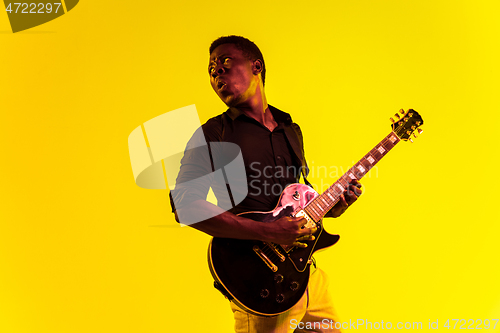 Image of Young african-american jazz musician playing the guitar