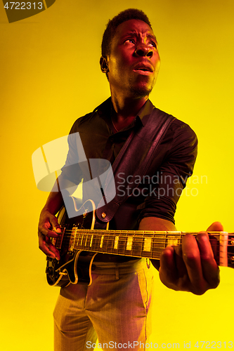 Image of Young african-american jazz musician playing the guitar