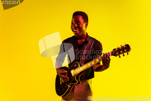 Image of Young african-american jazz musician playing the guitar