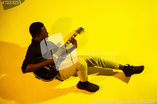 Image of Young african-american jazz musician playing the guitar