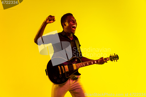 Image of Young african-american jazz musician playing the guitar